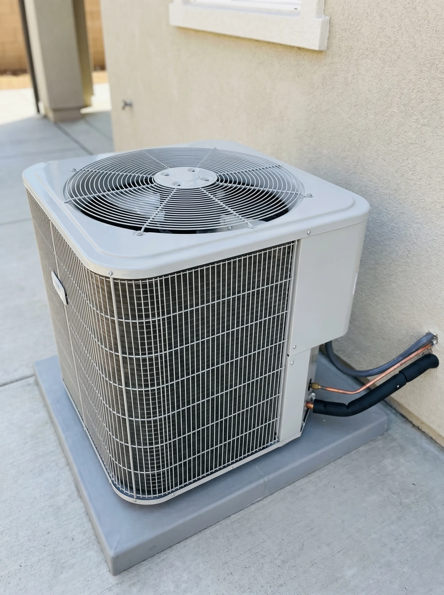 Outdoor AC condenser tucked into a Utah home's xeriscape side yard.